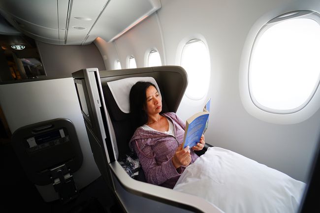 Une femme se détendant sur un vol en première classe avec un livre