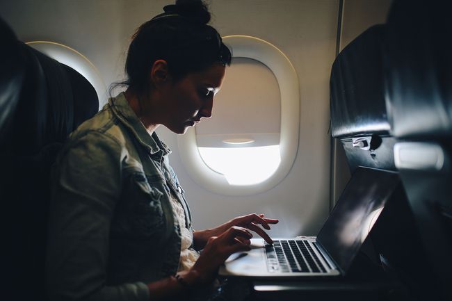 Jeune femme finissant son travail en avion