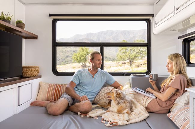 Véhicule vivant, camping-car de luxe avec un homme et une femme modélisant l'utilisation des espaces