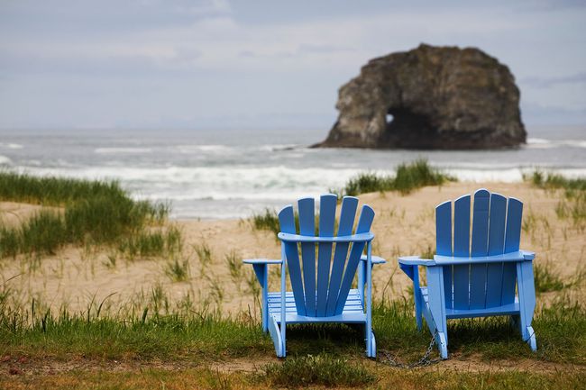 Deux chaises Adirondack bleues sur une plage herbeuse de Rockaway dans l'Oregon