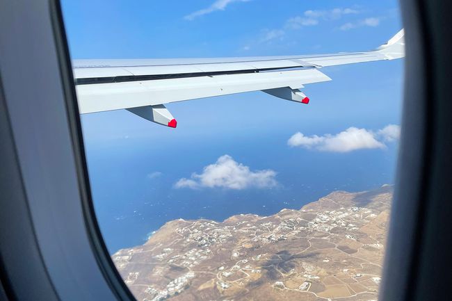 Regarder par la fenêtre d'un avion au-dessus de Mykonos
