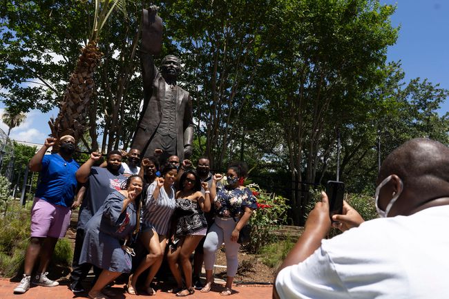 Les gens posent devant la statue de l'ancien représentant du Texas, Al Edwards