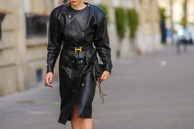 Emy Venturini porte une longue robe croisée en cuir noir de Saint-Laurent YSL vintage à Paris, France.