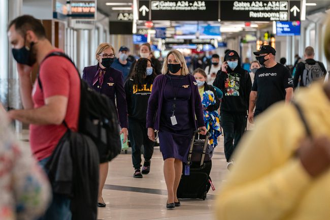 Des agents de bord portant des masques de protection traversent l'aéroport international Hartsfield-Jackson d'Atlanta à Atlanta