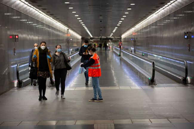 Un volontaire de la Croix-Rouge livre un masque aux passagers de la gare de Diagonal en Espagne.