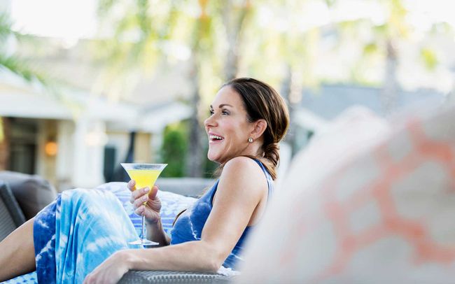 Femme mûre avec martini relaxant dans un jardin