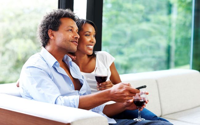 Couple avec du vin en regardant la télévision