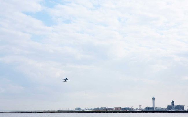 Un avion décollant de l'aéroport au bord de la mer.