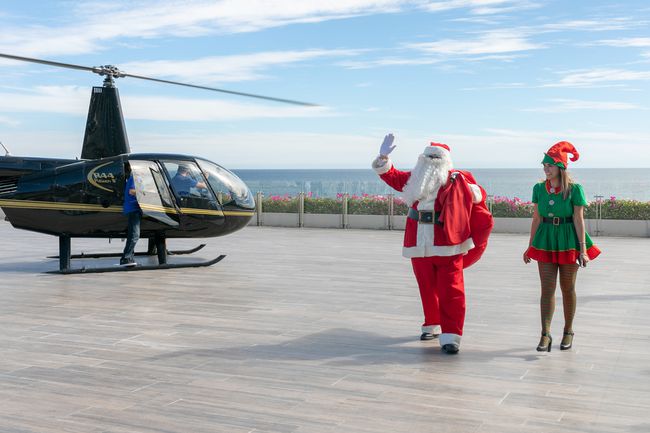 Le Père Noël arrive avec un elfe par hélicoptère à Grand Velas Los Cabo