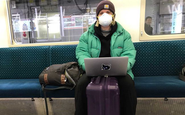 L'écrivain, Eve Carrick, dans le train à Tokyo avec un masque de protection.
