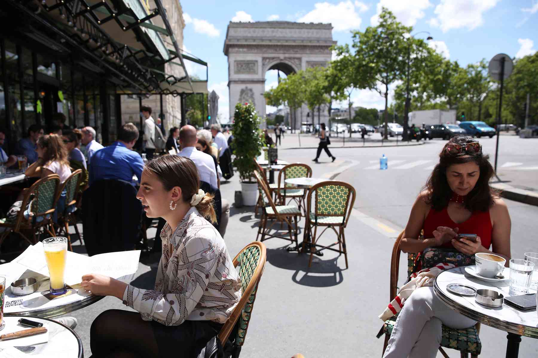 Des gens déjeunent dans un restaurant près de l'Arc de Triomphe à Paris, France, le 18 juin 2020