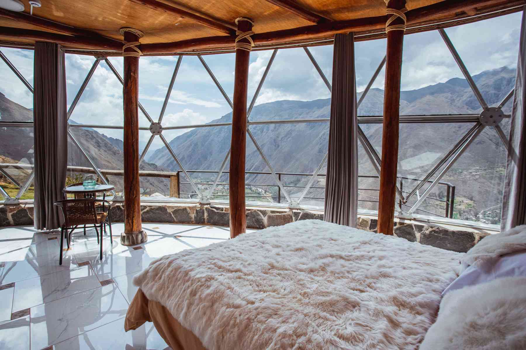 Hôtel-boutique de luxe avec une structure en dôme transparent niché dans les montagnes du Pérou.  Vues panoramiques depuis l'intérieur de la chambre et du restaurant