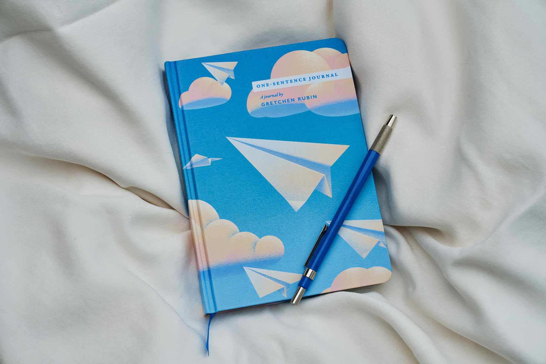 Journal bleu avec des avions en papier sur la couverture