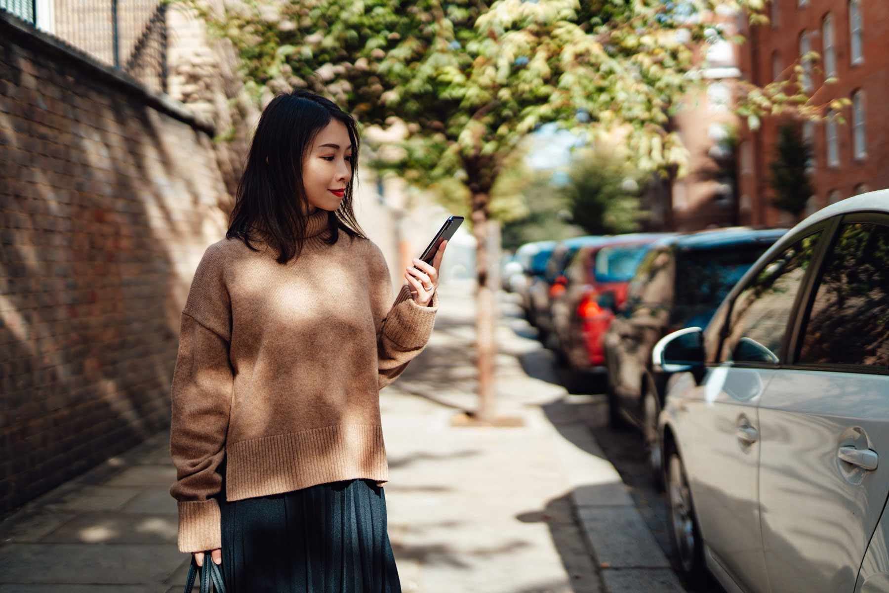 Femme asiatique à la recherche d'une voiture sur une application téléphonique