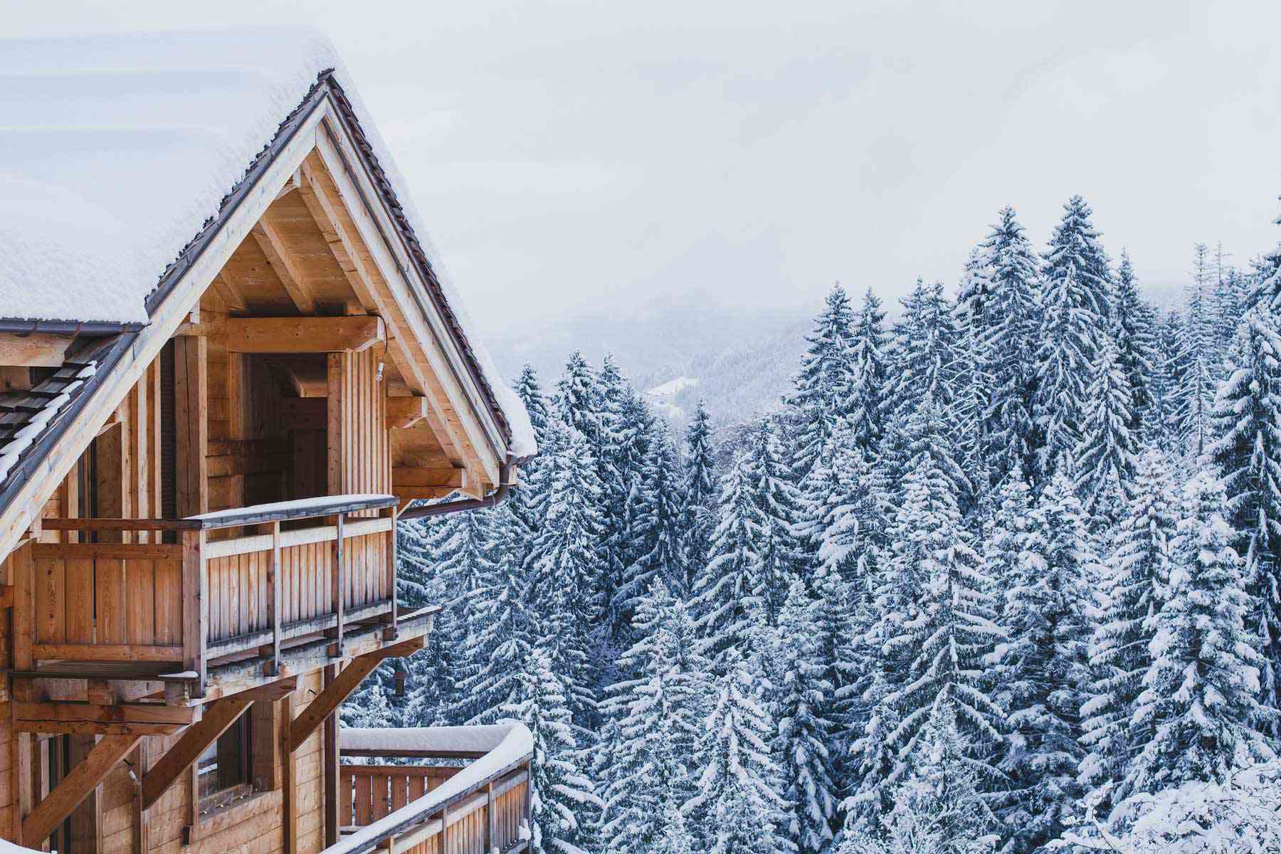 Une maison de cabane en bois dans le décor de montagne d'hiver de neige de pins