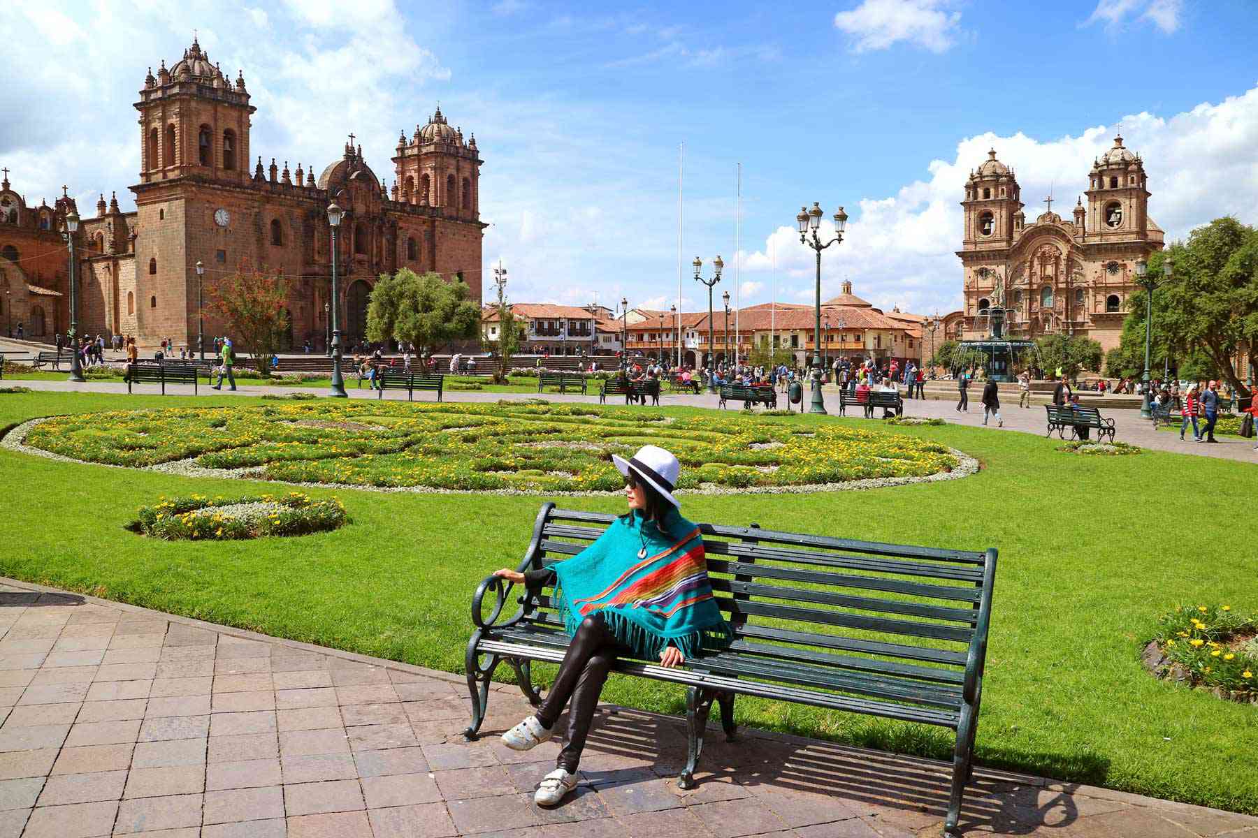 Femme assise sur un banc contre des bâtiments à Cusco, Pérou
