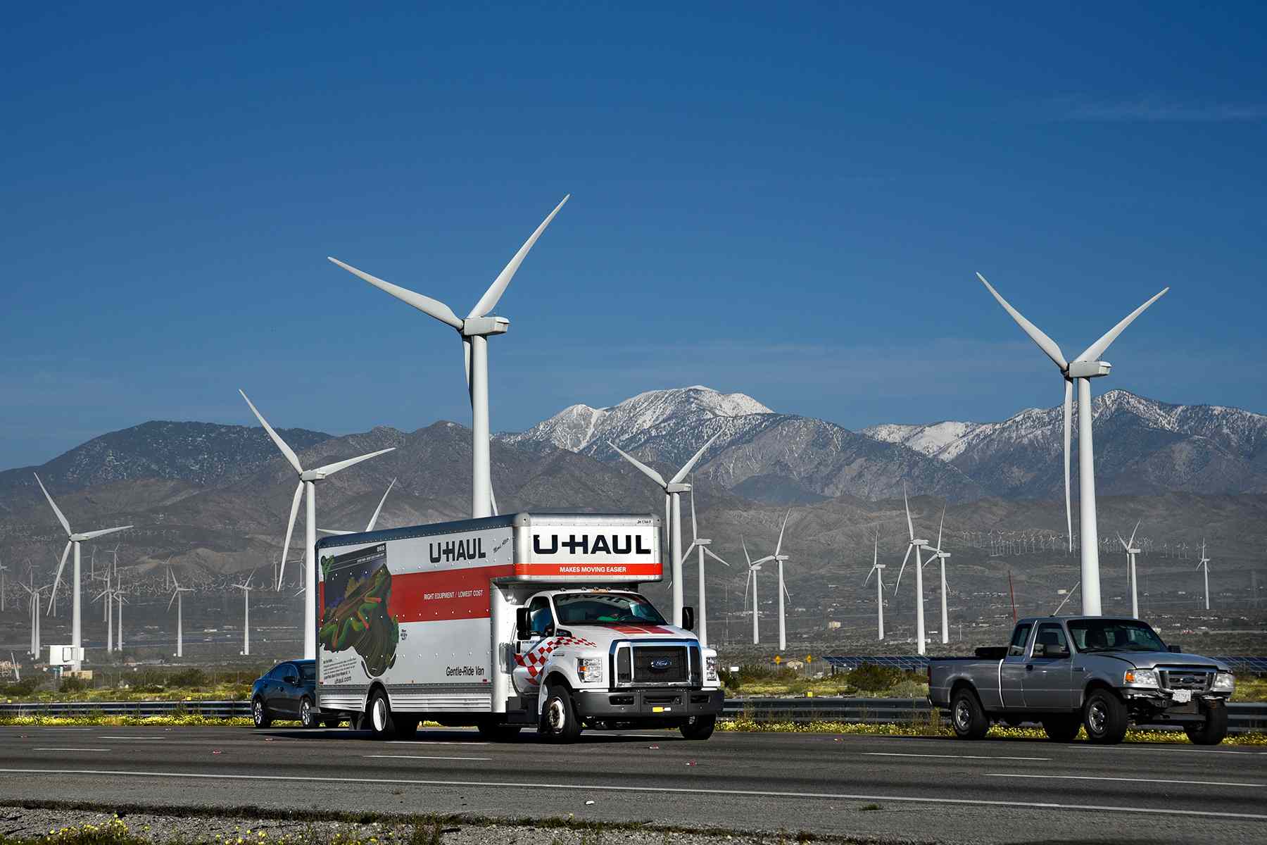 Un camion U-Haul et d'autres véhicules voyagent le long de l'Interstate 10 et du parc éolien de San Gorgonio Pass près de Palm Springs, en Californie.