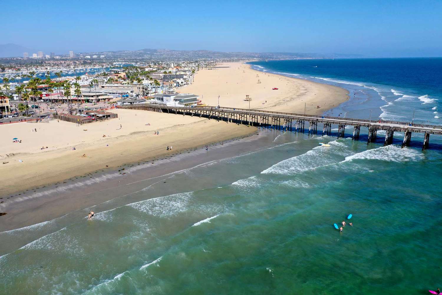 Une vue aérienne de quelques surfeurs et amateurs de plage profitant d'une belle journée à la plage malgré la fermeture ferme du gouverneur Gavin Newsoms, qui est toujours en place à Newport Beach, Californie, le 4 mai 2020.