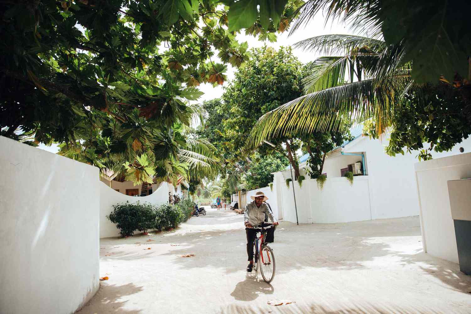 Homme faisant du vélo dans la rue à l'île d'Ukulhas, aux Maldives.