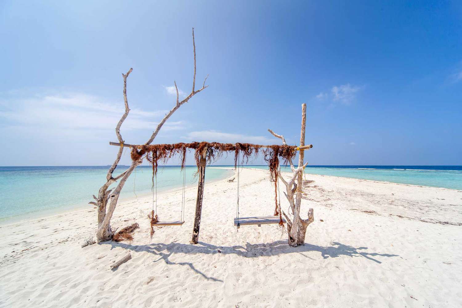 L'incroyable île d'Omadhoo aux Maldives, avec une belle plage de sable blanc et une eau turquoise.