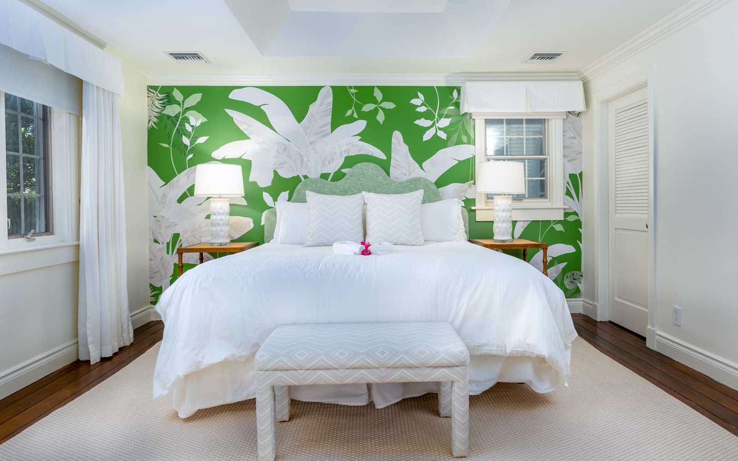 Une chambre d'hôtes au complexe hôtelier Point Grace dans les îles Turques et Caïques, avec un mur imprimé tropical vert et blanc