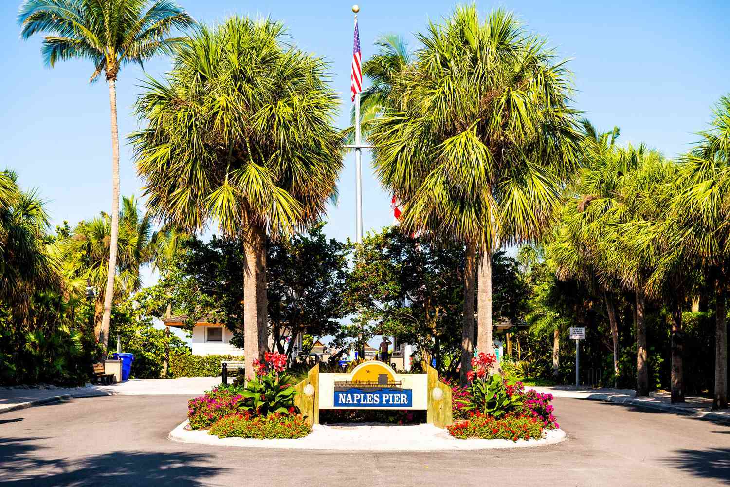 Jetée de Naples, panneau d'entrée de Floride avec palmiers et drapeau américain sur mât dans la communauté de quartier riche