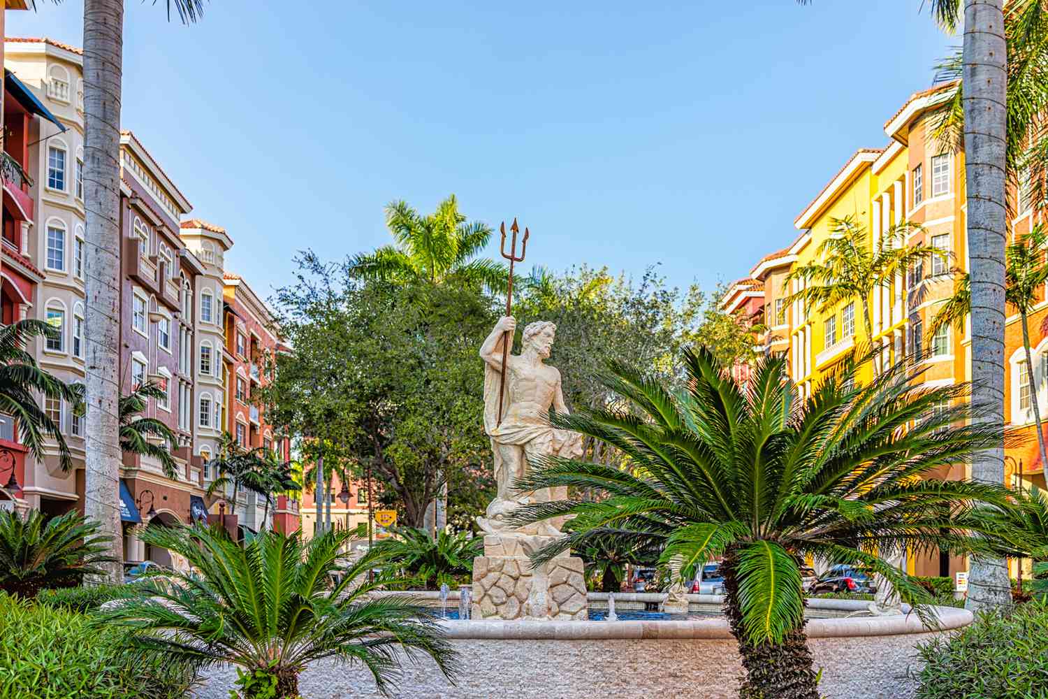 Bâtiments multicolores colorés de condos Bayfront avec fontaine à eau et statue du dieu grec Poséidon de l'eau en Floride