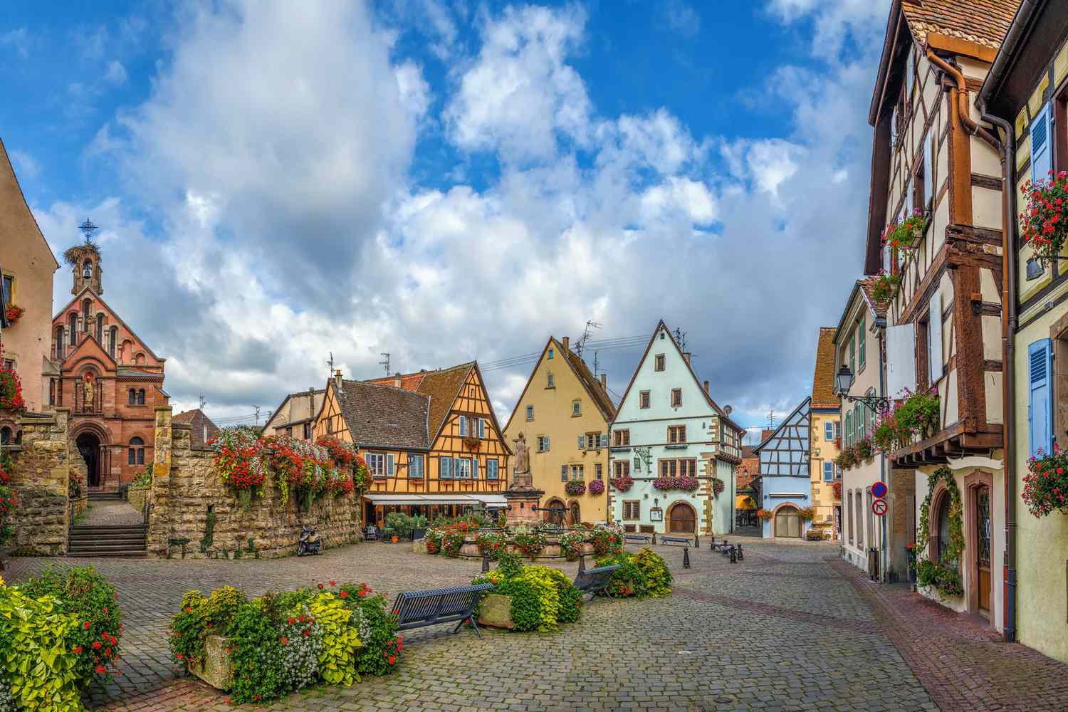 Place principale avec église et fontaine avec statue du pape Léon IX à Eguisheim, Alsace, France
