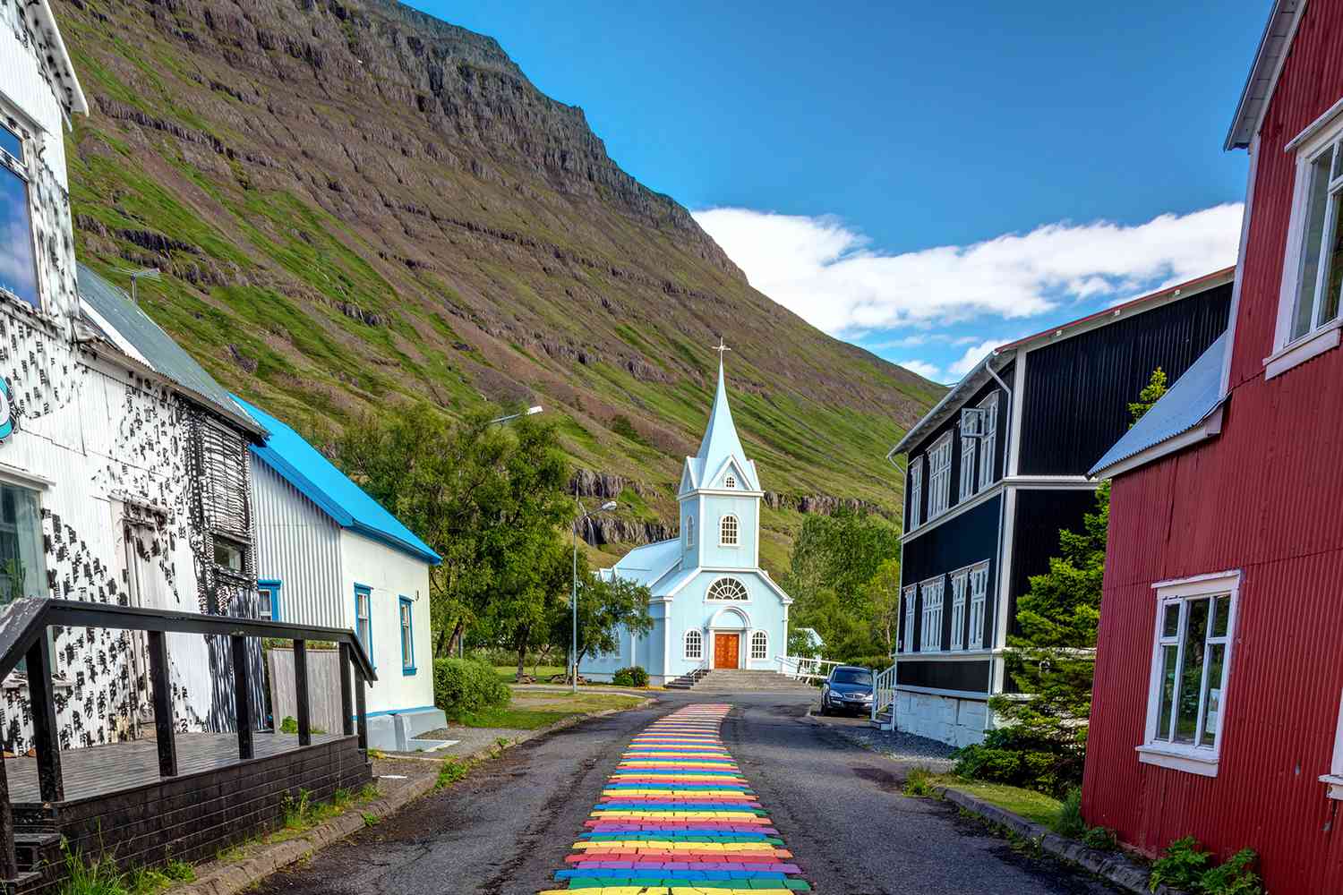 Passerelle arc-en-ciel coloré menant à une petite église dans la ville pittoresque de seydisfjordur dans le Fjord oriental de l'Islande
