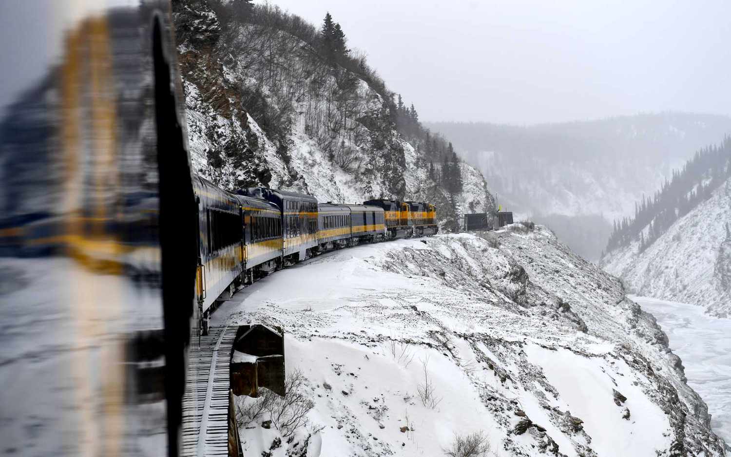 Le nord de l'Alaska Railroad's Denali Star se dirige à travers la gorge de la rivière Nenana alors qu'il se dirige vers Fairbanks le 27 février 2018 à Healy, AK