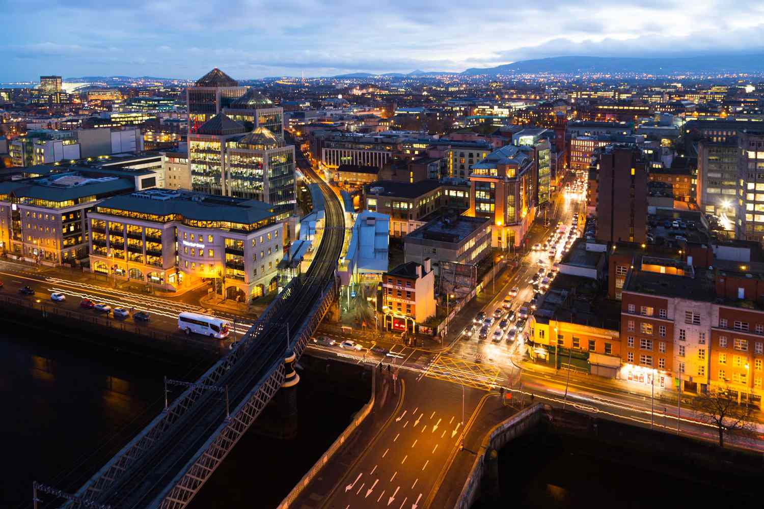Un point de vue sur les ponts le long de la rivière Liffey en direction de la zone des Docklands la nuit à Dublin, Irlande