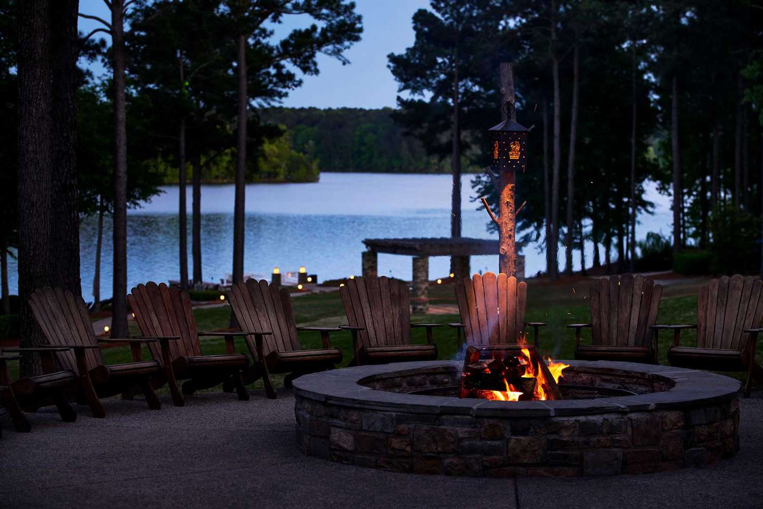 Chaises près d'un feu devant un lac