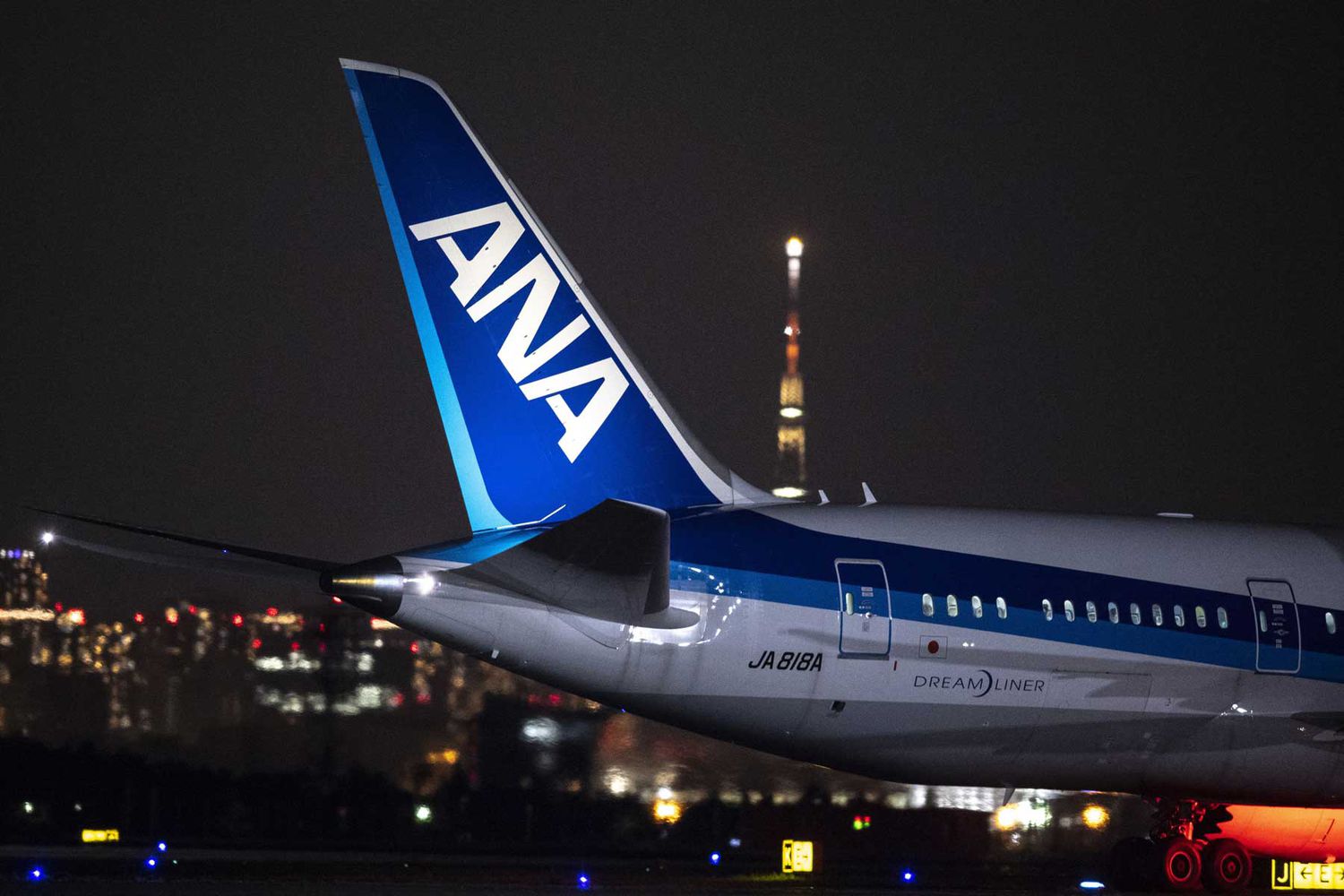La queue d'un avion ANA, illuminée la nuit